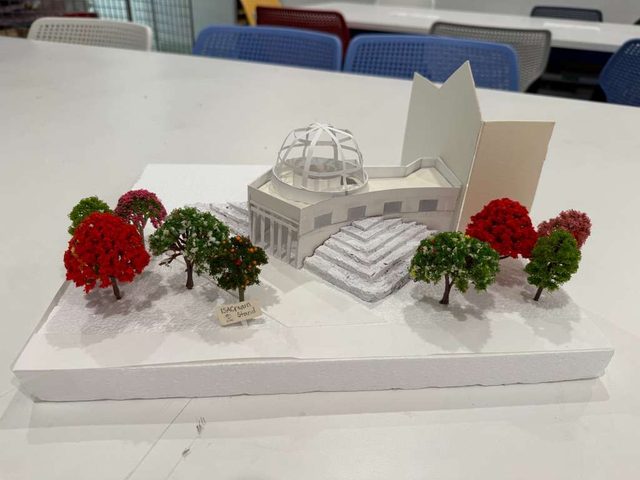 The completed white model with dome and model trees, photographed on a classroom table