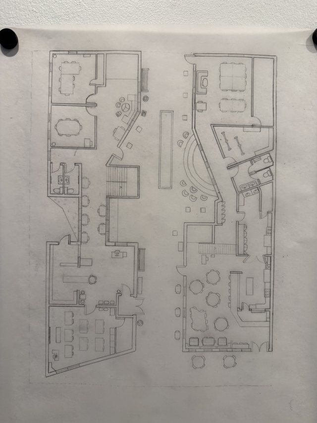 Pencil ground-floor plan on tracing paper, rooms and furniture drawn around a central spine